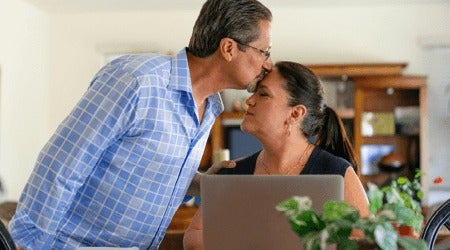 Man kissing woman on forehead