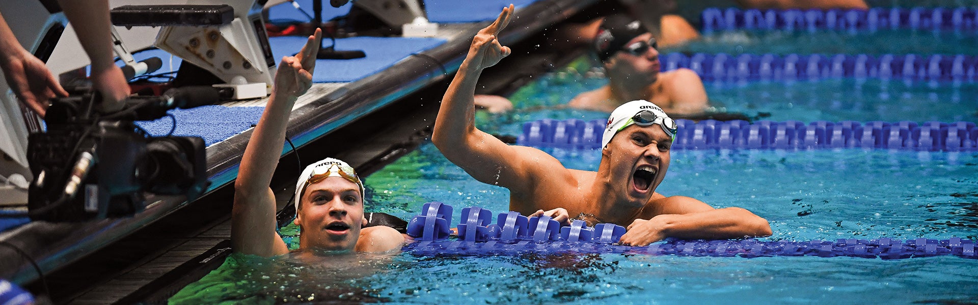 Swimmers in pool showing pitchfork hand sign