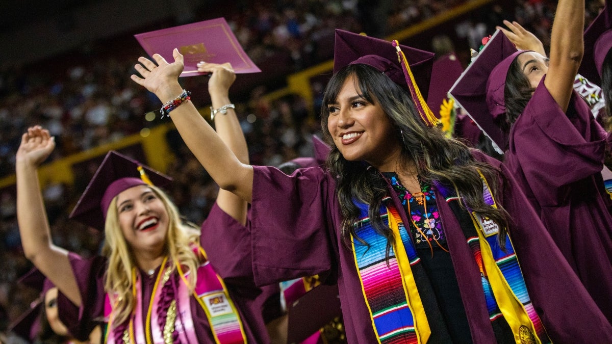 ASU Sun Devil graduates in commencement regalia wave and celebrate